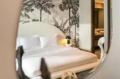 a bedroom with a bed with palm trees on the wall at Desert Living Luxury Condo - Jumeirah Living Marina Gate in Dubai