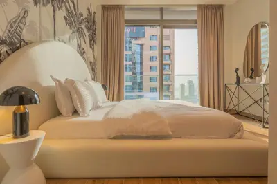 a bedroom with a large bed with a large window at Desert Living Luxury Condo - Jumeirah Living Marina Gate in Dubai
