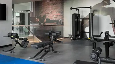 a fitness room with a woman lying on a bed in a gym at Desert Living Luxury Condo - Jumeirah Living Marina Gate in Dubai