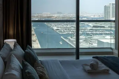 a bedroom with a large window looking out at a harbor at Vacay Lettings - 2BHK with Dubai Marina View in Dubai