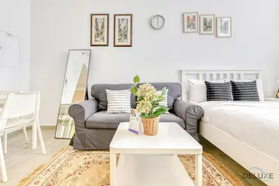 a living room with a couch and a table at Cheerful Studio at Belgravia Tower JVC by Deluxe Holiday homes in Dubai