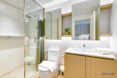a bathroom with a shower and a toilet and a sink at Cheerful Studio at Belgravia Tower JVC by Deluxe Holiday homes in Dubai