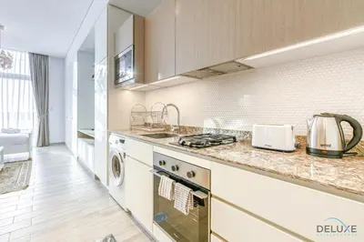 a kitchen with a sink and a stove top oven at Cheerful Studio at Belgravia Tower JVC by Deluxe Holiday homes in Dubai