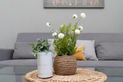 two vases with flowers on a table in a living room at White Sage - Elegant Apartment With Unobstructed City Views in Dubai