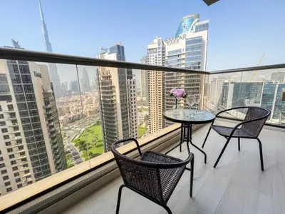 a balcony with a table and chairs and a view of a city at Luton Vacation Homes - Elite Downtown Residence, Burj Khalifa View Dubai - 19AB01 in Dubai