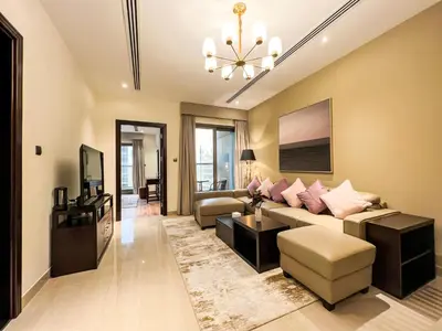 a living room with a couch and a tv at Luton Vacation Homes - Elite Downtown Residence, Burj Khalifa View Dubai - 19AB01 in Dubai