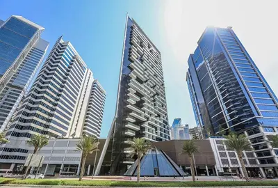 a group of tall buildings in a city with palm trees at Luxury Studios with Burj Khalifa View or Canal view - Marquise Square Tower in Dubai