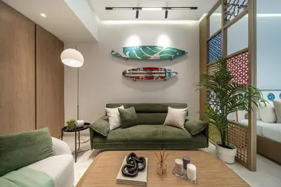 a living room with a green couch and a table at Luxury Studios with Burj Khalifa View or Canal view - Marquise Square Tower in Dubai