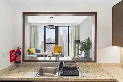 a kitchen counter with a sink and a mirror at Silkhaus modern Boulevard 1BDR near Burj Khalifa in Downtown in Dubai