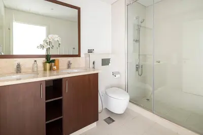 a bathroom with a toilet and a glass shower at Frank Porter - Boulevard Crescent in Dubai