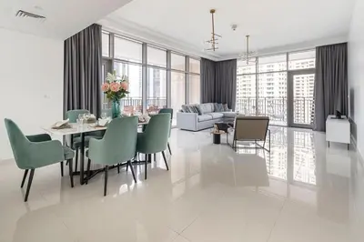 a dining room with a table and green chairs at Frank Porter - Boulevard Crescent in Dubai