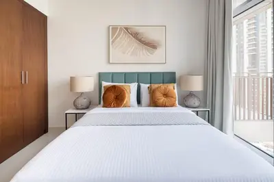 a bedroom with a large white bed with two lamps at Frank Porter - Boulevard Crescent in Dubai