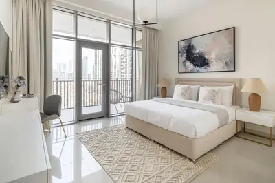a white bedroom with a large bed and a balcony at Frank Porter - Boulevard Crescent in Dubai