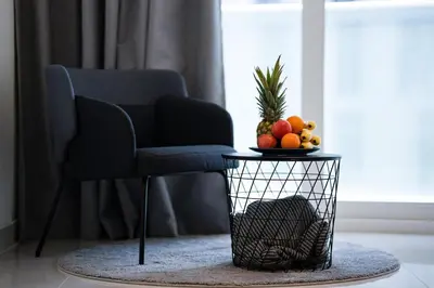 a table with a bowl of fruit and a chair at AWS Holiday Homes - Unique Views at Damac Heights in Dubai