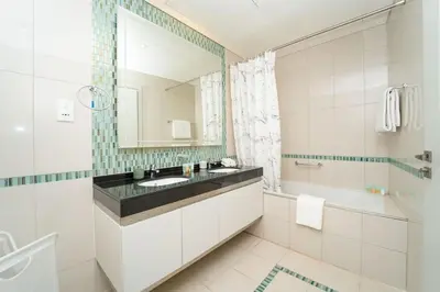 a bathroom with a sink and a tub and a mirror at AWS Holiday Homes - Unique Views at Damac Heights in Dubai