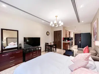 a bedroom with a large white bed and a television at Luton Vacation Homes - Elite Downtown Residence Studio, Burj Khalifa View Dubai - 80AB3 in Dubai