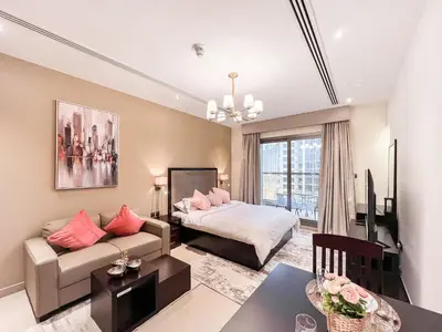a living room with a couch and a bed at Luton Vacation Homes - Elite Downtown Residence Studio, Burj Khalifa View Dubai - 80AB3 in Dubai