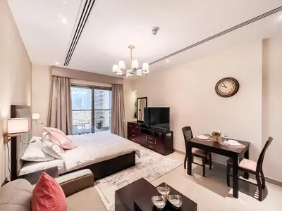 a bedroom with a bed and a living room at Luton Vacation Homes - Elite Downtown Residence Studio, Burj Khalifa View Dubai - 80AB3 in Dubai