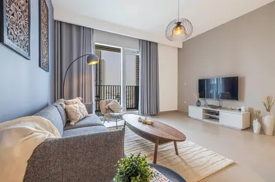 a living room with a couch and a table at Daniels 1BR at Creek Horizon with Park View in Dubai