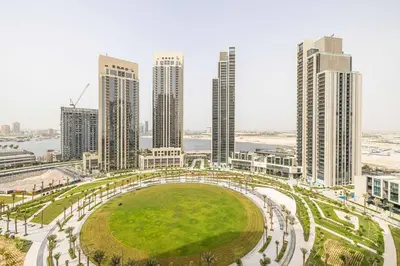 a view of a city with tall buildings and a park at Daniels 1BR at Creek Horizon with Park View in Dubai