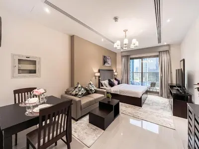 a living room with a bed and a dining room at Luton Vacation Homes - Elite Residence Downtown, Dubai in Dubai