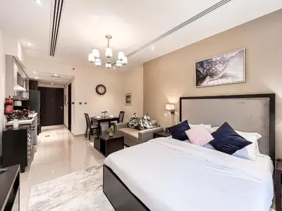 a bedroom with a large bed and a living room at Luton Vacation Homes - Elite Residence Downtown, Dubai in Dubai