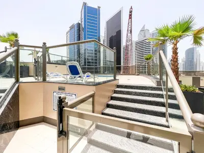 a balcony with stairs and a chair and a city at Luton Vacation Homes - Elite Residence Downtown, Dubai in Dubai