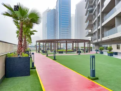 a pavilion with a palm tree on a green field at Mira Holiday Homes - Furnished studio in Downtown in Dubai