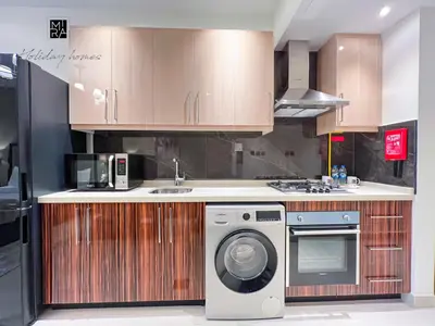 a kitchen with a washing machine and a sink at Mira Holiday Homes - Furnished studio in Downtown in Dubai
