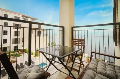 a balcony with a table and chairs and a view of the ocean at Outstanding New Apartment with Sea View In La Mer in Dubai
