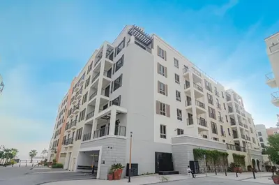a large white apartment building on a street at Outstanding New Apartment with Sea View In La Mer in Dubai