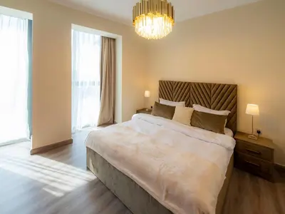 a bedroom with a large bed and a chandelier at Stylish 3BR Burj Khalifa, Fountain Views, Pool & Prime Location in Dubai