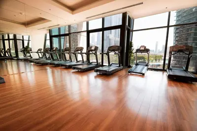 a gym with a row of treadmills in a building at Stylish 3BR Burj Khalifa, Fountain Views, Pool & Prime Location in Dubai