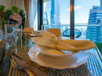 a table with a bowl and a napkin on it at Stylish 3BR Burj Khalifa, Fountain Views, Pool & Prime Location in Dubai