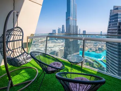a balcony with chairs and a view of the city at Stylish 3BR Burj Khalifa, Fountain Views, Pool & Prime Location in Dubai
