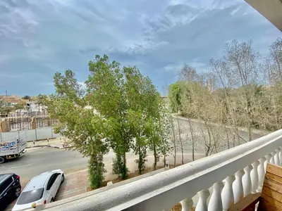 a balcony with a view of trees and a parking lot at Comfortable Private Rooms in Compound Housing in Dubai