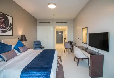 a bedroom with a large bed and a flat screen tv at Premium Studio with Beautiful Golf Course View in Dubai