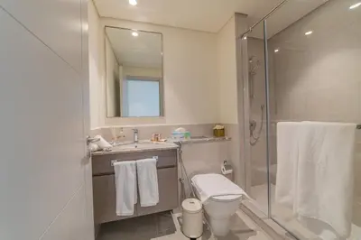 a bathroom with a shower and a toilet and a sink at FIRST CLASS 2BR with full DUBAI BOULEVARD view in Dubai