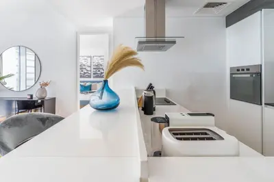 a white kitchen with a sink and a stove at GuestReady - Stunning Apartment in Bluewaters in Dubai