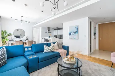 a living room with a blue couch and a table at GuestReady - Stunning Apartment in Bluewaters in Dubai
