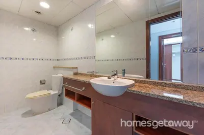 a bathroom with a sink and a toilet and a mirror at HomesGetaway -Fanciful 1BR Apartment in JLT Lake View in Dubai