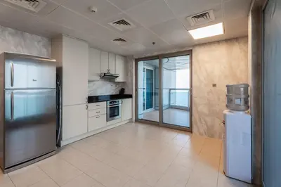 a kitchen with a stainless steel refrigerator and a window at Veer Apartments - 82nd Floor Princess Tower - Palm View in Dubai