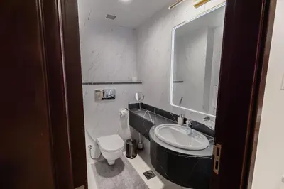 a bathroom with a sink and a toilet and a mirror at Veer Apartments - 82nd Floor Princess Tower - Palm View in Dubai