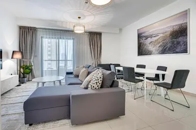 a living room with a blue bed and a dining room at 2 BD apartment in Bahar JBR in Dubai