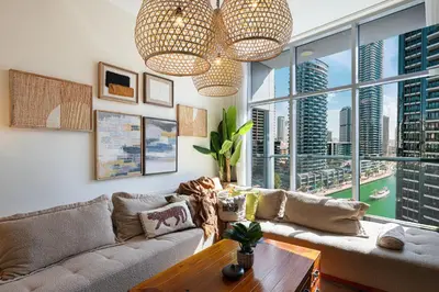 a living room with a couch and a large window at Stylish 3 bedrooms Boho-Style Home in Dubai
