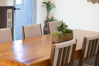 a wooden table with chairs and a basket of plants on it at Stylish 3 bedrooms Boho-Style Home in Dubai
