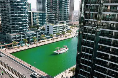 a boat in a river in a city with buildings at Stylish 3 bedrooms Boho-Style Home in Dubai