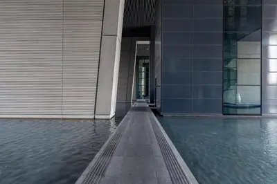 a building with a pool of water in front of it at Frank Porter - Index Tower in Dubai