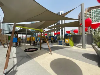 a playground with a large umbrella over a playground at GuestReady - Charming Loft 7mins from Burj Khalifa in Dubai
