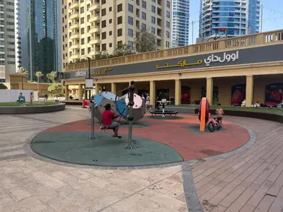a person sitting on a statue in front of a building at 2BD apartment in Bahar JBR near beach in Dubai